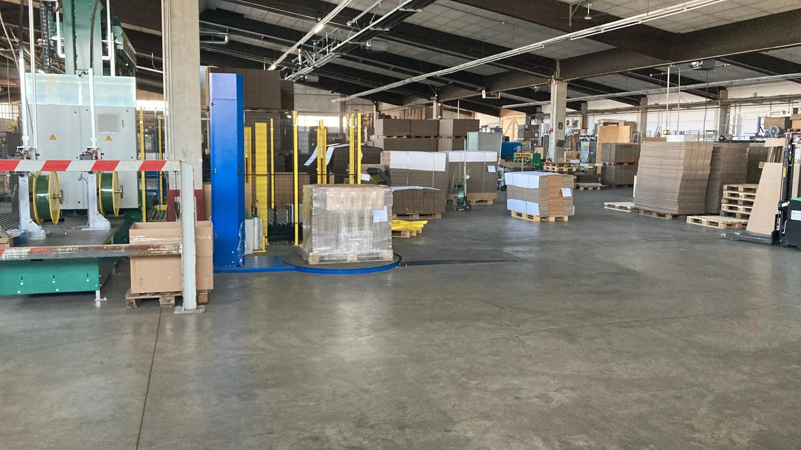 Productiehal met pallets verzenddozen en omsnoeringsmachine